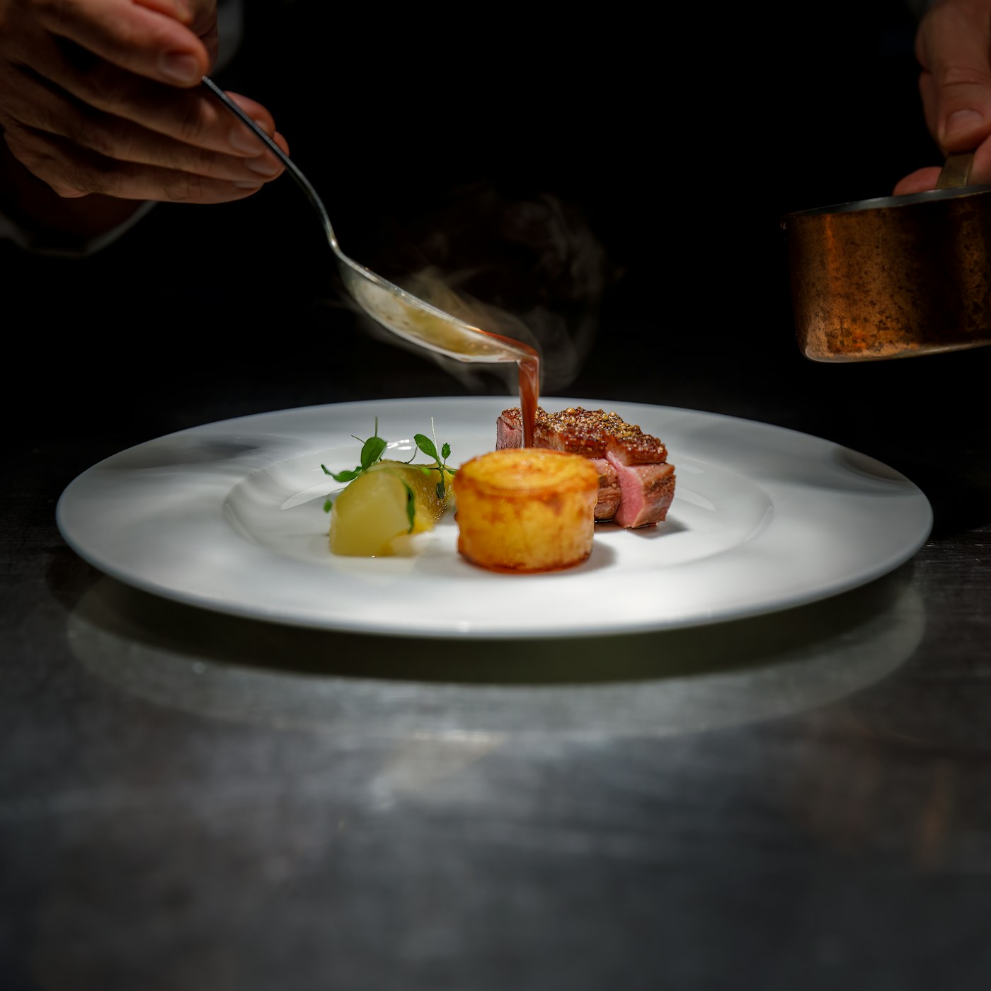 Chef finishing a seasonal main course